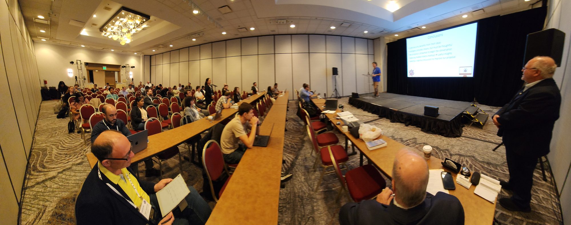 A HealthSec workshop session in progress, with a speaker presenting to a seated audience